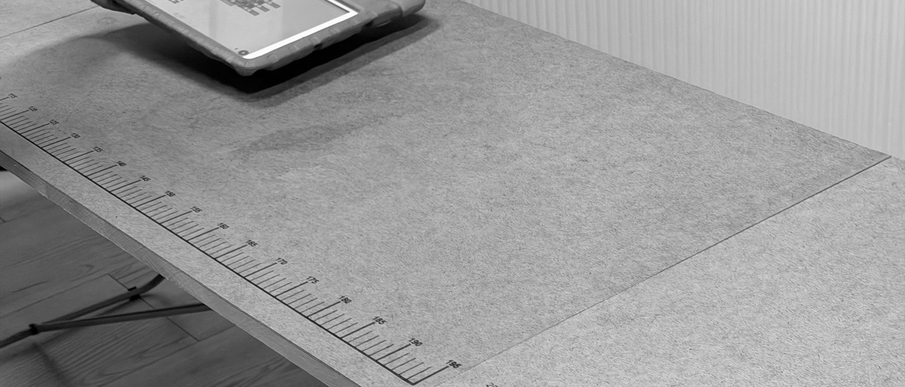 Een leeg werkblad met meetstrip en een tablet, voor de werkdag begint.